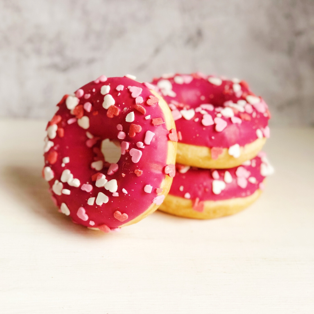Пончик-донат с клубничной начинкой, розовой глазурью и посыпкой в виде сердечек